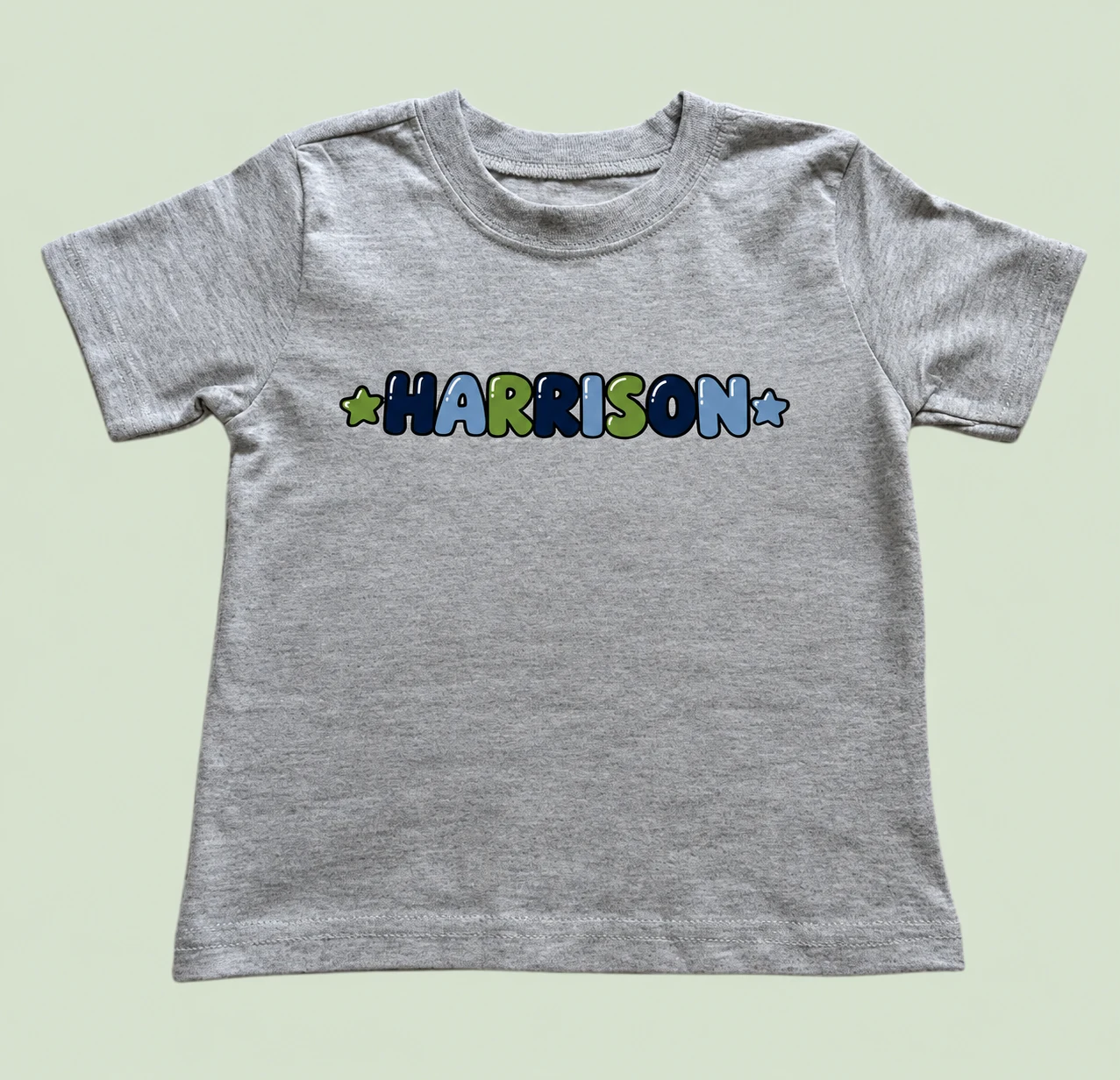 Harrison personalized tee on a light sage green background
